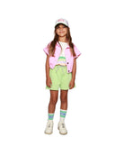 Girl model wearing Boxy Jacket in Pink over Crop Tee Vedette, combined with Cut off Jog Shorts in Paradise Green,  Cos I Said So Socks in White and the Ciss Cap.