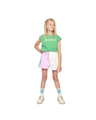 Girl model wearing the Après Sport Boxy Tee with the Color Block Cut Off Jog Shorts and the Cos I Said So Socks in White.