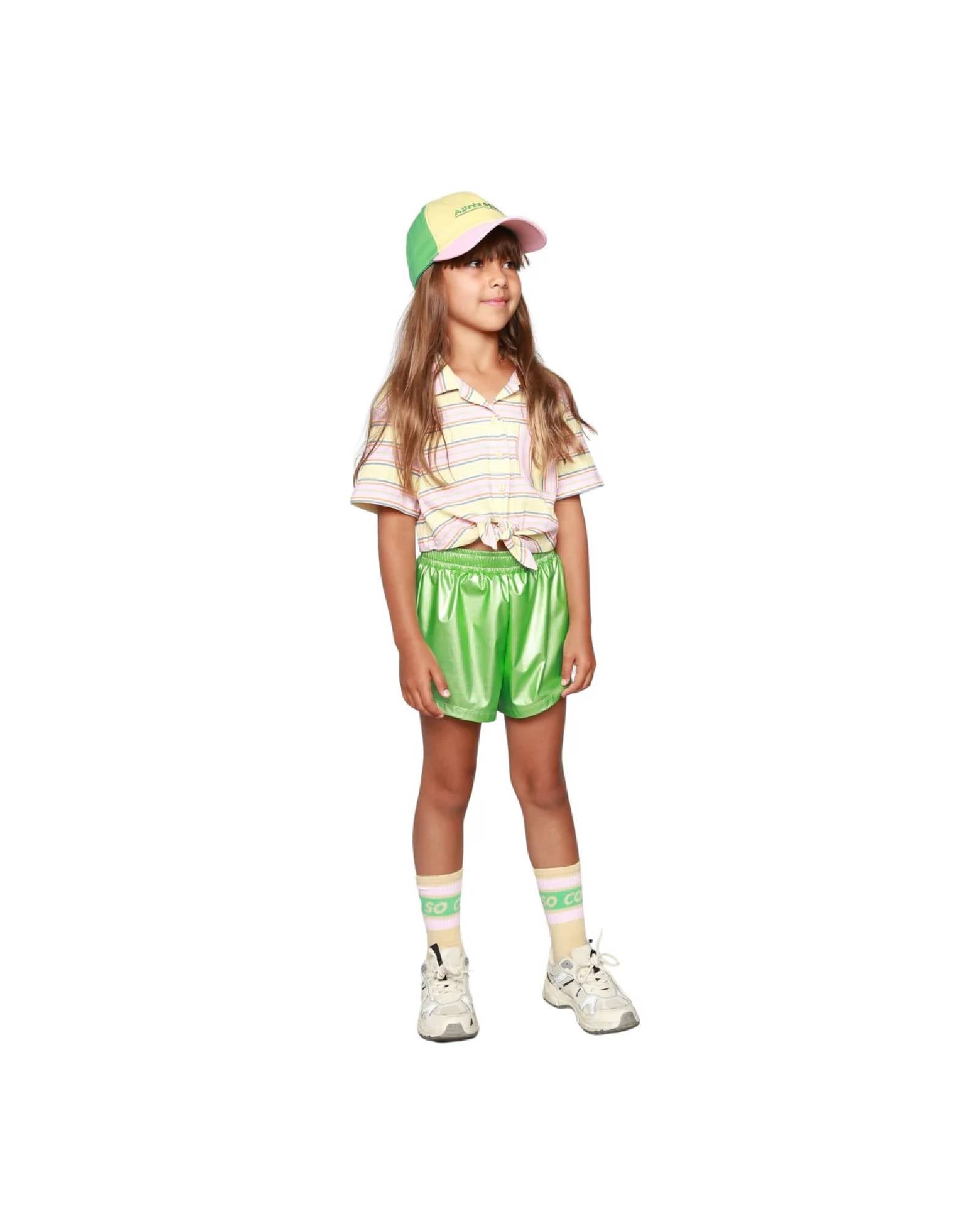 Girl model wearing the Vegan Shorts in lime Green with Ciss socks in Anise and the Après Sport Cap.