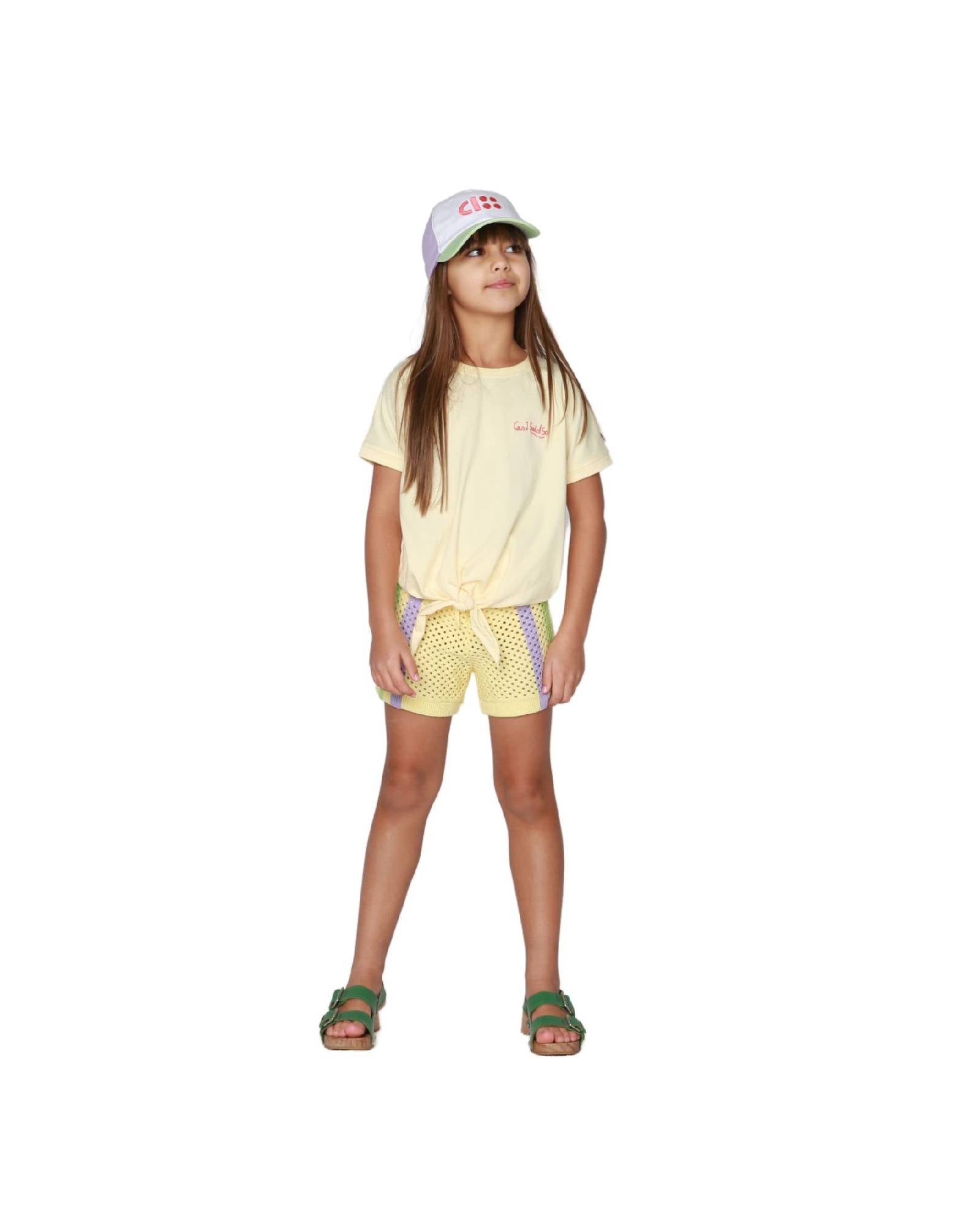 Girl model wearing the Crochet Shorts in Anise Yellow with a T-shirt in Anise Yellow, with the cap CISS.