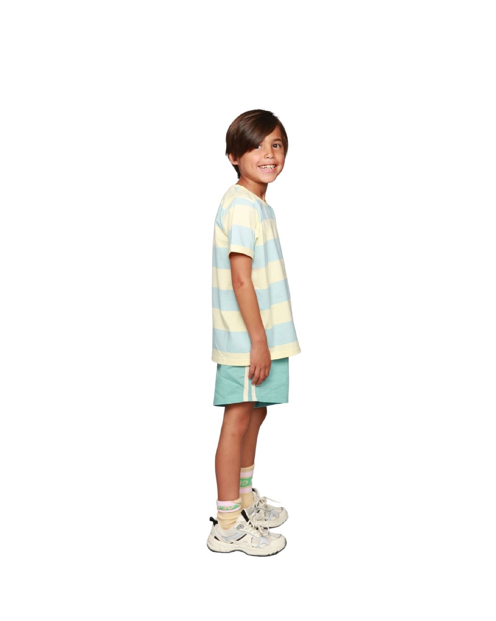 Boy model wearing the Linen Shorts in Turquoise with the Striped T-Shirt Aqua Haze Anise and the Socks Cos I said So in Anise Yellow.