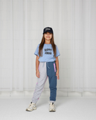 Girl wearing unisex Happy Human T-Shirt by Cos-I-Said-So in high quality Organic Cotton. T-Shirt shown in the color Brunnera Blue.