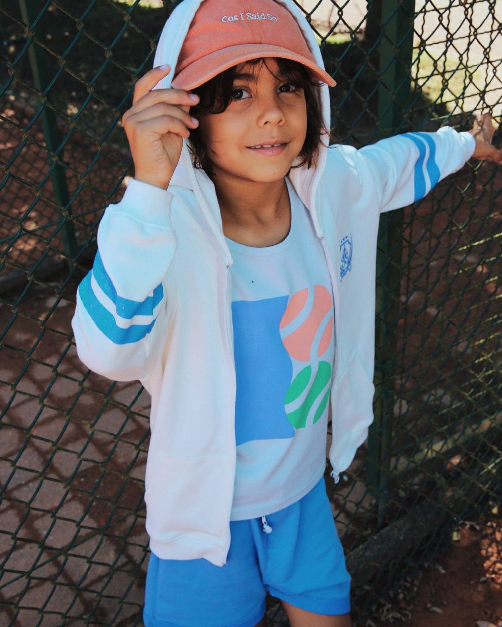 Boy model wearing the outfit Tennis Tank Top, combined with the Zip Hoodie and the Jog Shorts in Granada Sky.