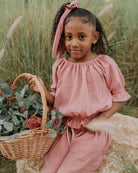 Girl model wearing the Alexa Top in Blush Pink Muslin Cotton, matching the Sienna Skirt in Blush Pink and the Scrunchie Long in Blush Pink.