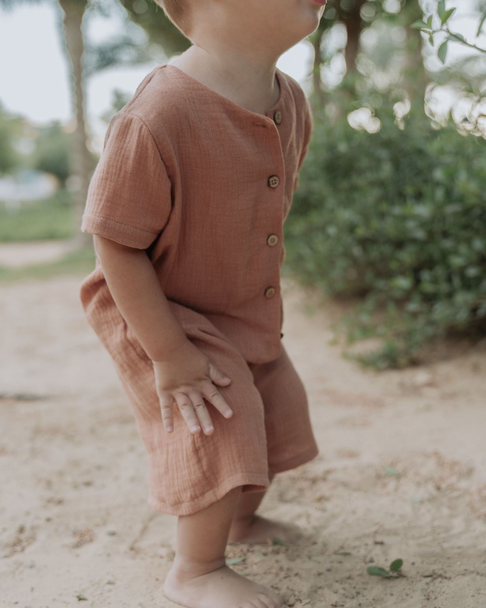 Boy Toddler wearing the Boys Onesie Noah in Caramel Muslin Cotton.