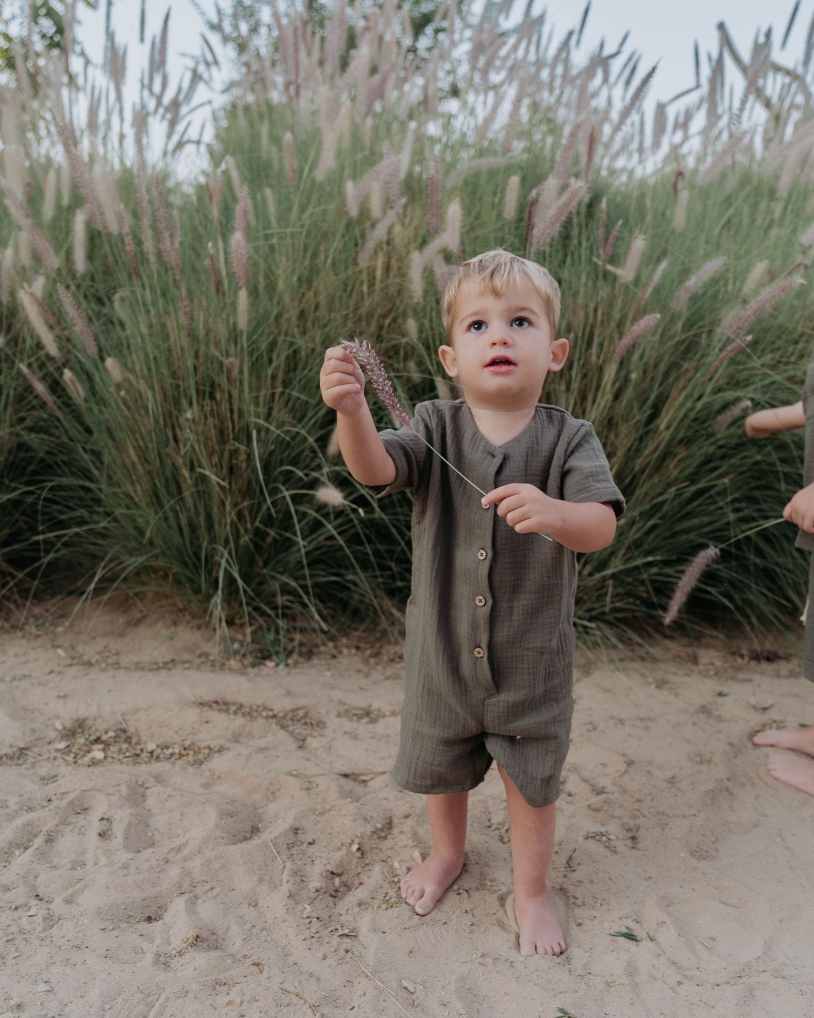 Boy Toddler wearing the Boys Onesie Noah in Soft Khaki Green Muslin Cotton.