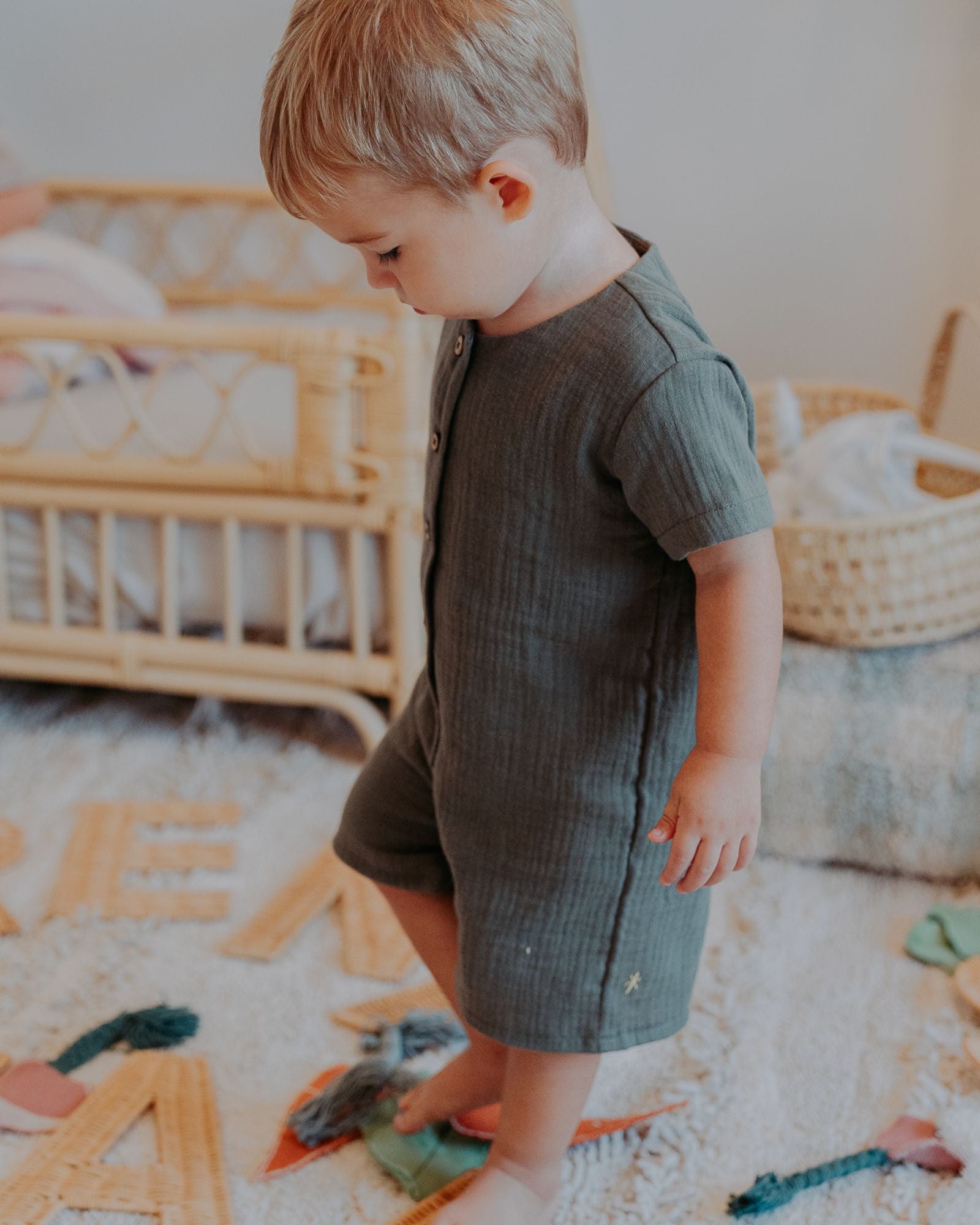 Boy Toddler wearing the Boys Onesie Noah in Soft Khaki Green Muslin Cotton.