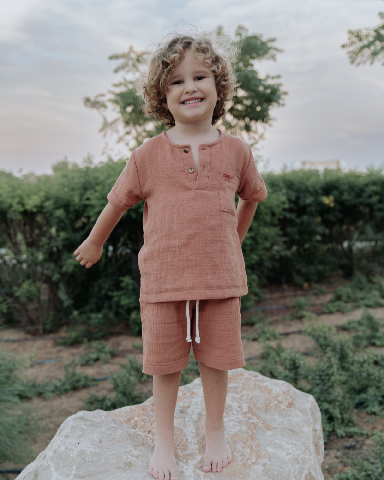 Boy model wearing the Charlie Shirt in the color Caramel, matching the Julian Shorts in Caramel Muslin Cotton.