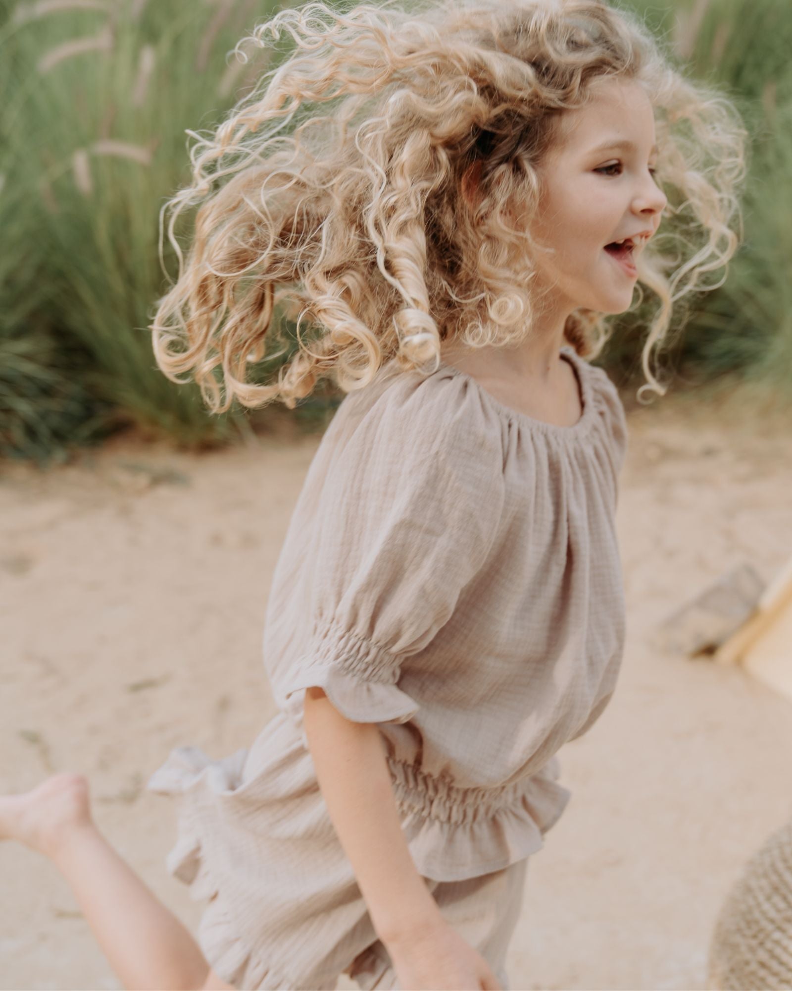 Girl model wearing the Alexa Top in Beige Muslin Cotton, combined with the Charlene Shorts in Beige Muslin Cotton.